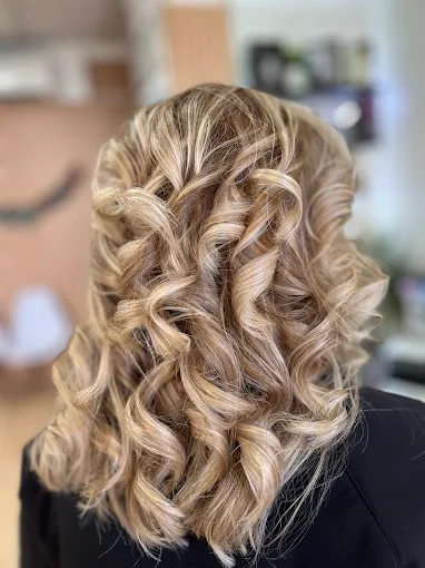 Mechas rubio platino con rizos definidos y volumen en Salón Aurora